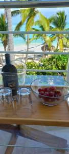 a table with a bowl of fruit and a bottle of wine at Private room overlooking the beach in Punta Cana