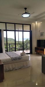 a bedroom with a bed and a large window at Taylors Country Home by Taylors Traveller's Inn- The Grande Second Floor in Catarman