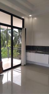 a kitchen with a large sliding glass door with a balcony at Taylors Country Home by Taylors Traveller's Inn- The Grande Second Floor in Catarman