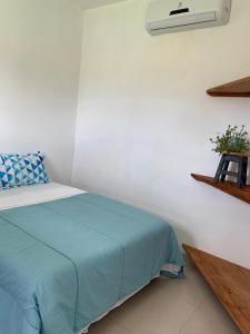 1 dormitorio con 1 cama con edredón azul en COCONUTS FLATS, en Barra Grande