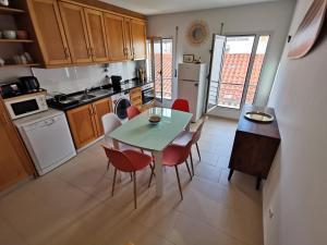 a kitchen with a table and chairs in a room at Casa na onda Liberdade in Nazaré