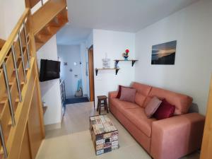 a living room with a couch and a staircase at Casa na onda Liberdade in Nazaré