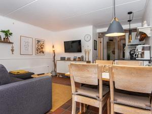 uma sala de estar com um sofá, uma mesa e cadeiras em Holiday Home Golfvejen VII em Fanø