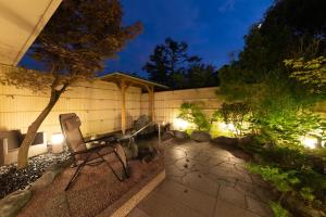 una silla en un jardín por la noche con luces en 富士山の見える全室個室サウナ付旅館 しずく, en Yamanakako