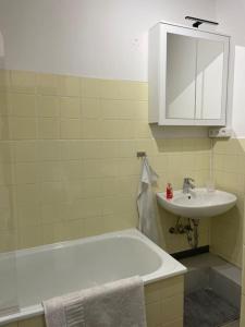 a bathroom with a sink and a tub and a mirror at Tower View Apartment in Lübeck