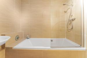 a bath tub with a shower and a sink at Modern 1BR flat - free parking + lift in Edinburgh +28 photos