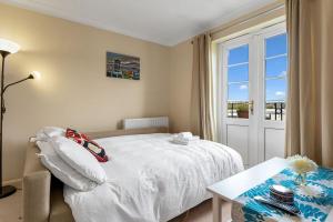 a bedroom with a bed and a table and a window at Modern 1BR flat - free parking + lift in Edinburgh