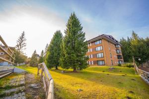 um edifício com um jardim relvado em frente a um edifício em Appartamento con Vista! A Due Passi dalle Piste em Madonna di Campiglio