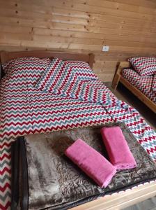 a bed with two pink pillows on top of it at Homoljski Raj Banja Zdrelo in Ždrelo