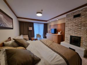 a hotel room with a large bed and a fireplace at Apartman Lukas privatni app u sklopu aparthotela Vučko in Jahorina