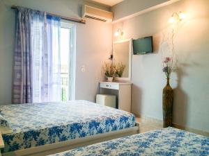 a hotel room with two beds and a window at Athina Studios in Argasi
