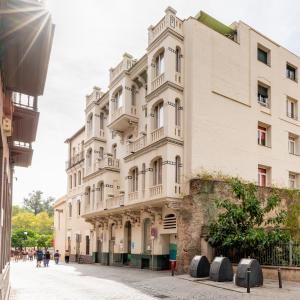 duży biały budynek na ulicy w obiekcie Sevilla Central Suites Apartamentos Puerta Jerez w Sewilli