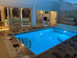 a swimming pool with blue lighting in a house at Villa LAGUNA in Lowlands