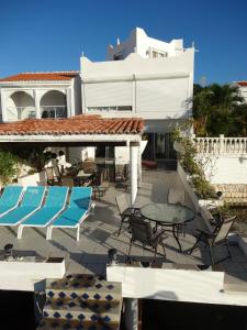 a patio with chairs and tables and a building at Villa LAGUNA in Lowlands