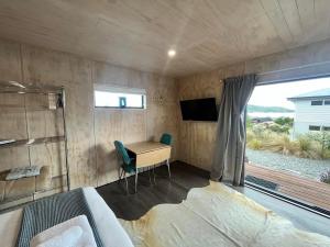 1 dormitorio con escritorio, TV y cama en Wayfarer Lodge Studio en Lake Tekapo