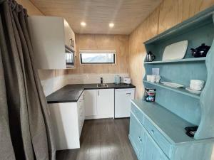eine kleine Küche mit weißen Schränken und einem Waschbecken in der Unterkunft Wayfarer Lodge Studio in Lake Tekapo