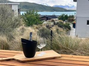 a bottle of wine and two glasses on a table at Wayfarer Lodge Studio in Lake Tekapo