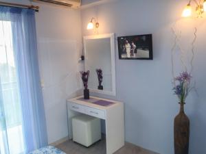 a bathroom with a white vanity and a mirror at Athina Studios in Argasi