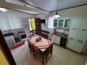 cocina con mesa y cocina con fogones en Casa da cachoeira - Ilhabela, en Ilhabela