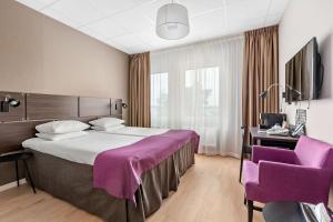 um quarto de hotel com uma cama grande e cadeiras roxas em Best Western Plus Park Airport Hotel em Arlanda