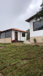 a house with a grass field in front of it at Chalé Lírio do Campo in Ouro Preto