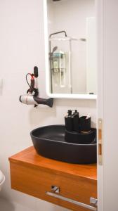 baño con lavabo negro y espejo en City Center 8 - Tirana Way Apartments, en Tirana