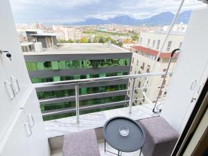 - Balcón con mesa y sillas en un edificio en City Center 8 - Tirana Way Apartments, en Tirana
