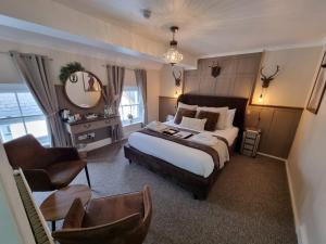 1 dormitorio con cama, silla y espejo en Creates en Monmouth