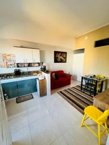 a living room with a red couch and a kitchen at Apartamento encantador em salvador in Salvador