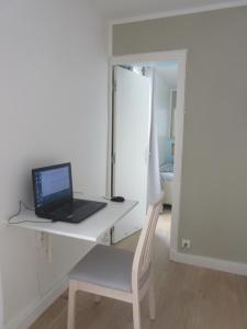a laptop computer sitting on a desk with a chair at Bourg-la-Reine : joli appartement de 20 m² in Bourg-la-Reine
