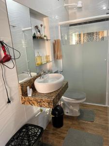 a bathroom with a sink and a toilet at Apartamento encantador em salvador in Salvador