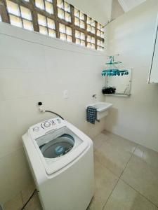 a small bathroom with a toilet and a sink at Apartamento encantador em salvador in Salvador