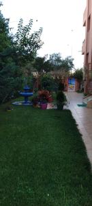 zielony dziedziniec ze stołem piknikowym w środku w obiekcie Villa Saraya w mieście Mehdiya-Plage