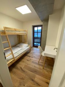 Cette chambre dispose de lits superposés et d'un bureau. dans l'établissement Wellness apartmán Pila Kvilda, à Kvilda