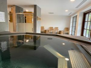una piscina en una habitación con algunas sillas en Wellness apartmán Pila Kvilda, en Kvilda