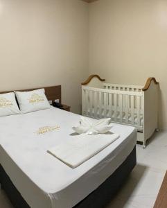 a white bed with a white flower on it at Hotel Estrela in Castanhal