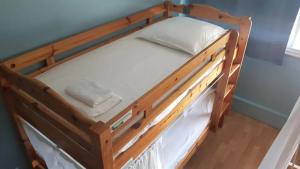 Litera de madera con almohada blanca en Bed & Working - Tramway - chambres partagées de 4 lits en Toulouse