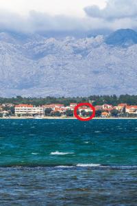 un frisbee rouge au milieu d'une masse d'eau dans l'établissement Apartments by the sea Vrsi - Mulo, Zadar - 5951, à Vrsi