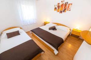 Ce lit se trouve dans un dortoir doté de murs blancs et de parquet. dans l'établissement Apartments by the sea Vrsi - Mulo, Zadar - 5951, à Vrsi