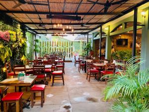 un ristorante con tavoli e sedie in legno e piante di Hotel León Inn a León