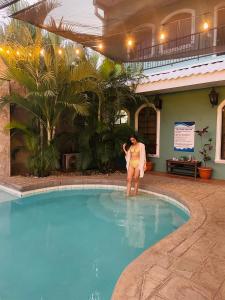 una donna in piedi in acqua in una piscina di Hotel León Inn a León