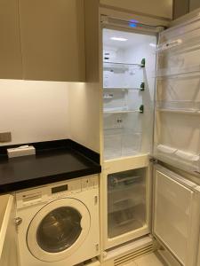 a kitchen with an empty refrigerator and a washing machine at داماك برماونت in Riyadh