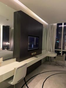 a room with a tv and a bed and a desk at داماك برماونت in Riyadh