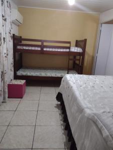 Habitación con cama y banco en una habitación en Pousada do Nico, en São Gabriel