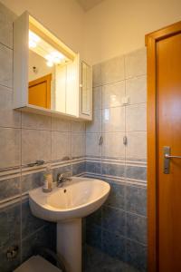 La salle de bains est pourvue d'un lavabo, d'un miroir et de toilettes. dans l'établissement Apartment Pasman 8274a, à Pašman