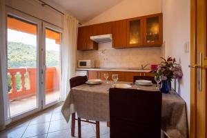 a kitchen with a table with chairs and a dining room at Apartment Pasman 8274a in Pašman