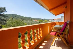 einen Balkon mit orangefarbenem Geländer sowie einem Tisch und Stühlen in der Unterkunft Apartment Pasman 8274a in Pašman