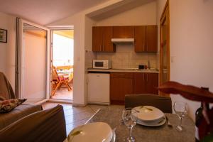 eine Küche und ein Wohnzimmer mit einem Tisch und Stühlen in der Unterkunft Apartments by the sea Pasman - 8274 in Pašman