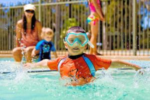 a young boy in a swimming pool with a mask on at Valla Beach Holiday Park in Valla Beach