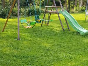 a group of swings in a park at Gîte familial avec piscine, idéal pour randonnées et pêche, proche Gérardmer et crêtes vosgiennes - FR-1-589-238 in Vienville
